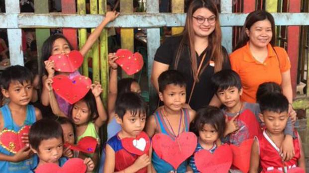 EFL staff with children holding red paper hearts
