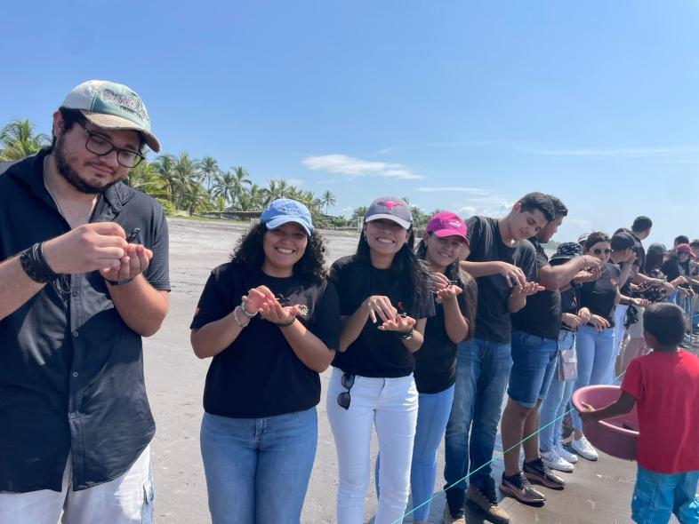 EFL El Salvador team holding sea turtles on a beach